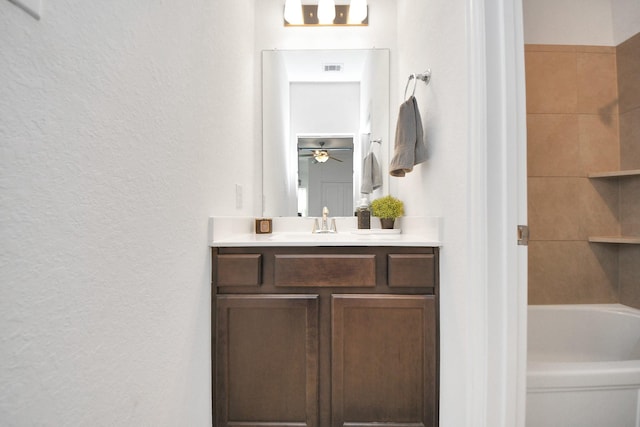 bathroom with vanity, a bathtub, and ceiling fan