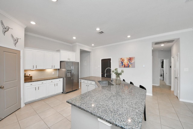 kitchen with sink, stainless steel fridge with ice dispenser, light tile patterned floors, a large island, and white cabinets