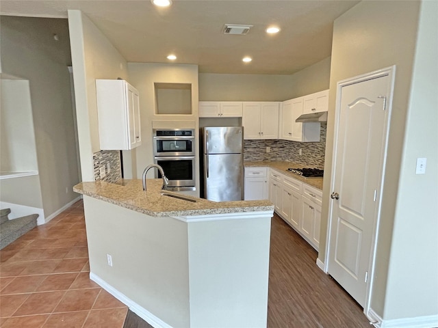 kitchen featuring sink, white cabinets, backsplash, tile patterned flooring, and stainless steel appliances