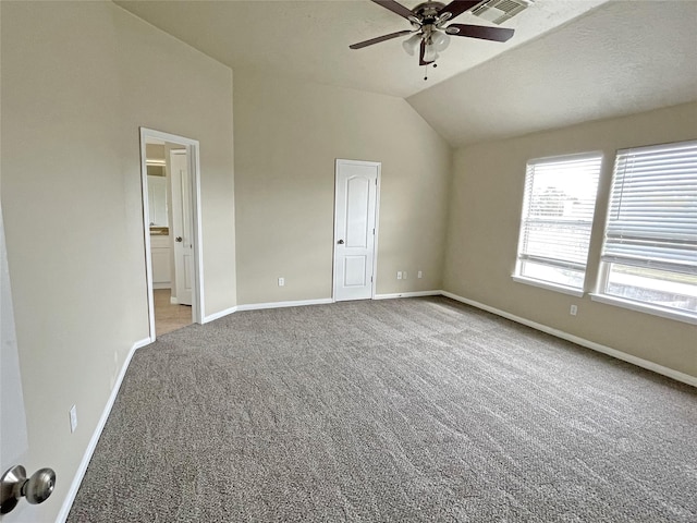 unfurnished bedroom featuring ceiling fan, vaulted ceiling, light carpet, and a textured ceiling