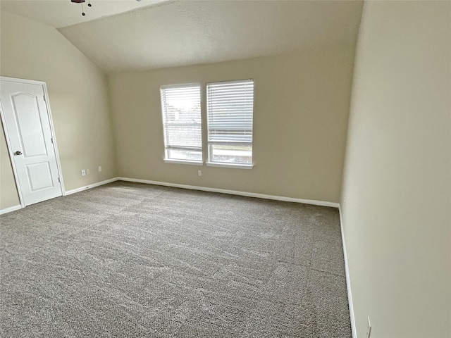 carpeted empty room with ceiling fan and vaulted ceiling