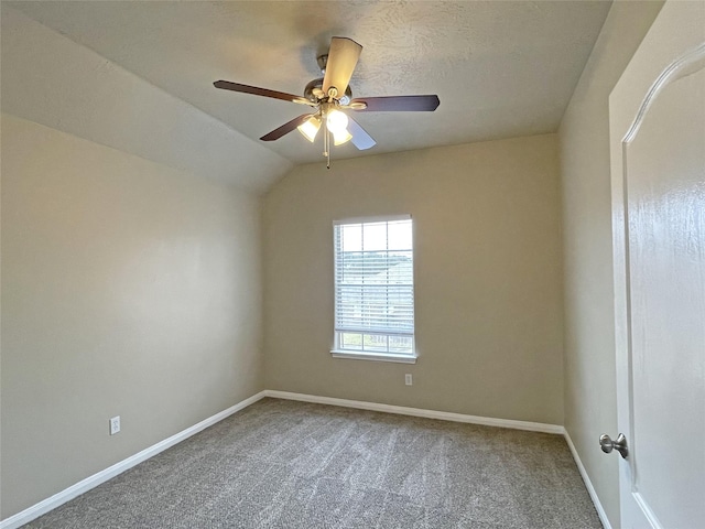 empty room with carpet floors, vaulted ceiling, and ceiling fan