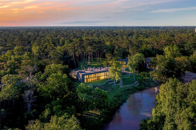 aerial view at dusk featuring a water view