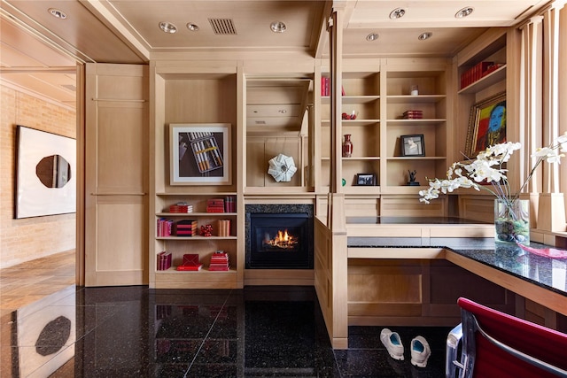 interior space featuring a lit fireplace, built in shelves, and recessed lighting