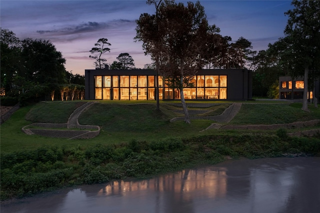 rear view of house featuring a lawn