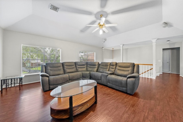 living room with decorative columns, ceiling fan, dark hardwood / wood-style flooring, and a tray ceiling