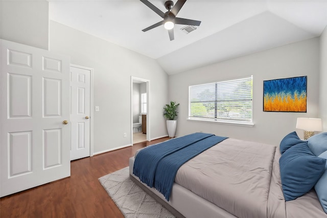 bedroom featuring dark hardwood / wood-style flooring, vaulted ceiling, ceiling fan, and ensuite bath