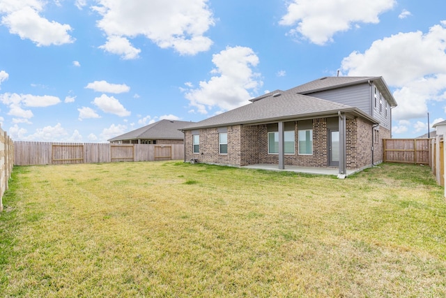 rear view of property with a yard and a patio area