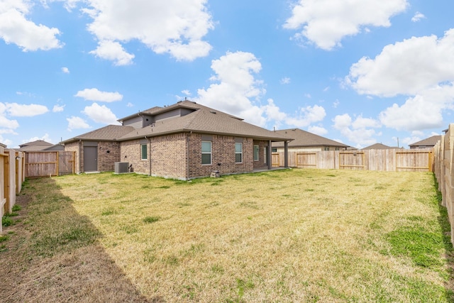 back of property with a lawn and central air condition unit