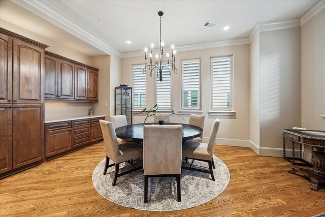 dining area featuring an inviting chandelier, crown molding, and light hardwood / wood-style floors