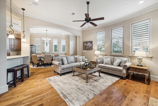 living room featuring ornamental molding, ceiling fan with notable chandelier, and light hardwood / wood-style floors