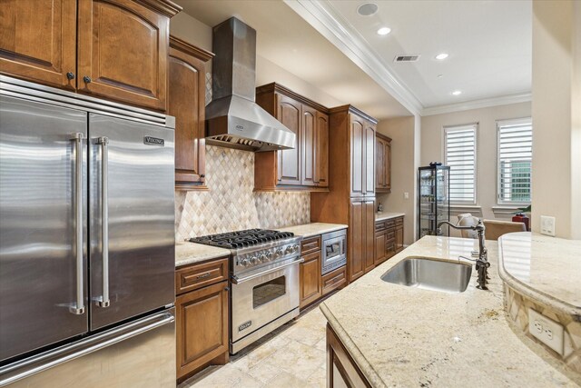 kitchen featuring sink, built in appliances, ornamental molding, light stone countertops, and wall chimney exhaust hood