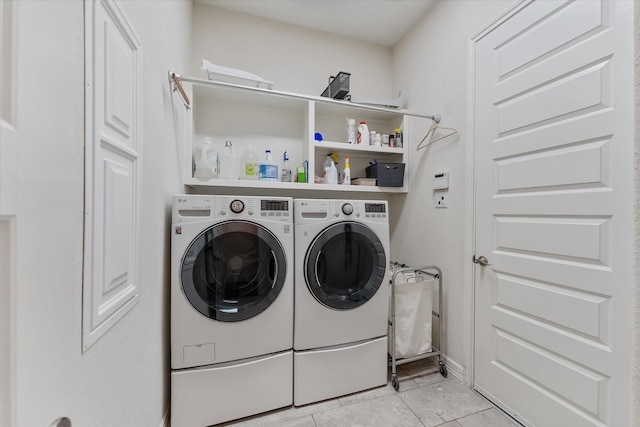 laundry area with washing machine and dryer and light tile patterned flooring