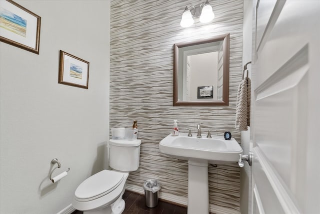 bathroom with wood-type flooring, toilet, and tile walls