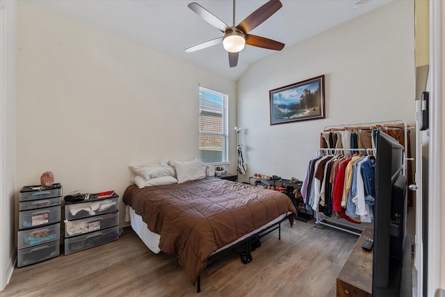 bedroom featuring hardwood / wood-style flooring, ceiling fan, lofted ceiling, and a closet