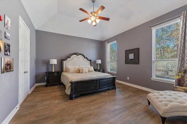 bedroom with a raised ceiling, dark hardwood / wood-style floors, and ceiling fan