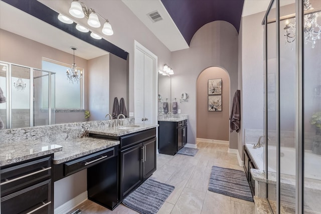 bathroom with vanity, plus walk in shower, and an inviting chandelier