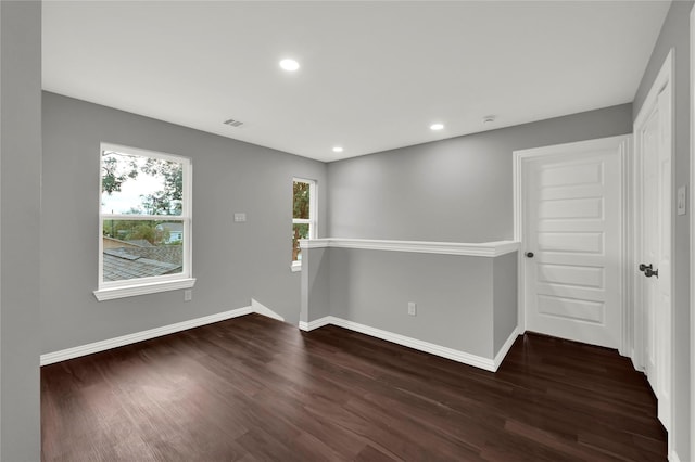 spare room featuring dark wood-type flooring, recessed lighting, visible vents, and baseboards