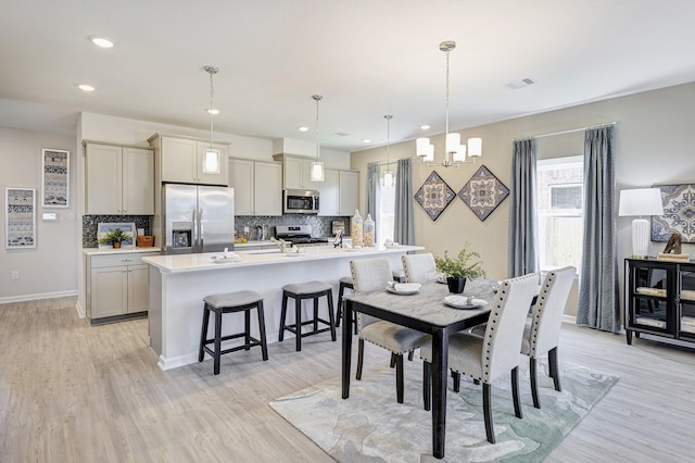 dining space featuring an inviting chandelier and light hardwood / wood-style flooring