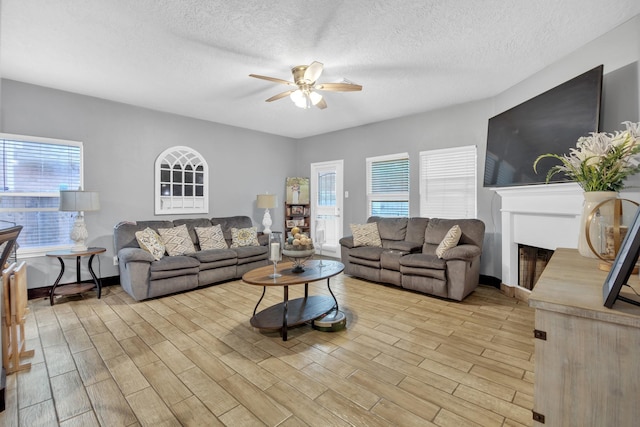 living room with a textured ceiling and ceiling fan