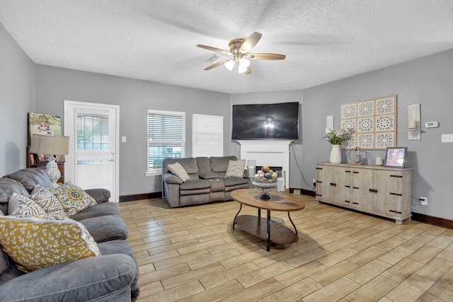 living room featuring a textured ceiling and ceiling fan