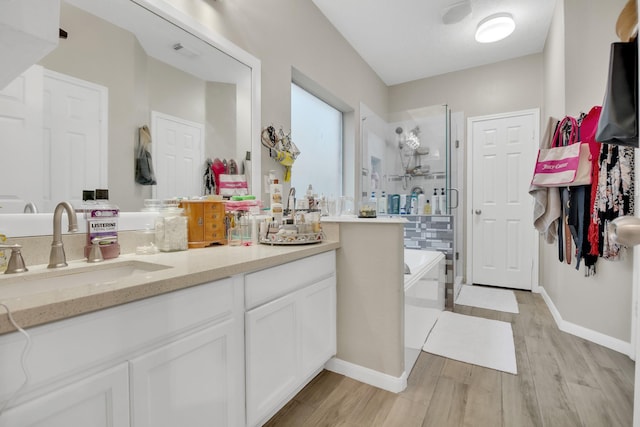 bathroom featuring vanity, hardwood / wood-style floors, and plus walk in shower