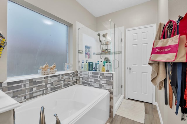 bathroom featuring hardwood / wood-style flooring and shower with separate bathtub