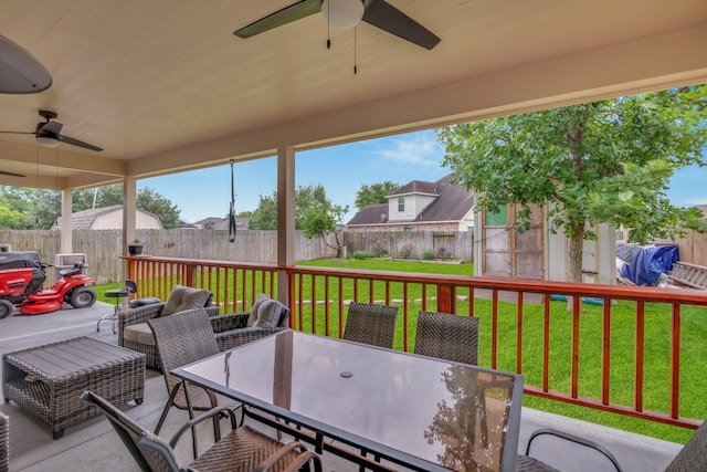 wooden terrace featuring ceiling fan and a lawn