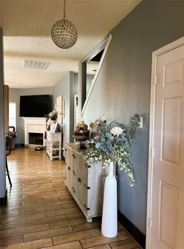 hallway with hardwood / wood-style floors and a textured ceiling