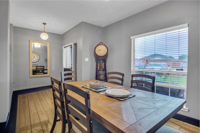 dining area featuring light hardwood / wood-style flooring and a textured ceiling