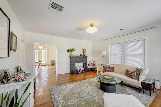 living room featuring hardwood / wood-style floors and a brick fireplace