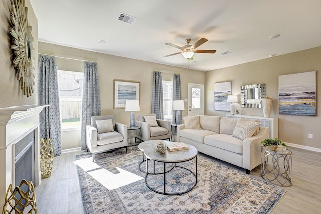 living room with light hardwood / wood-style floors and ceiling fan