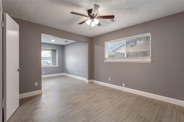 unfurnished room with ceiling fan, light hardwood / wood-style floors, and a textured ceiling