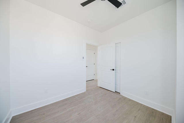 spare room featuring light wood-style floors, baseboards, and a ceiling fan