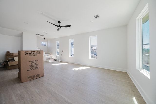 living area with baseboards, visible vents, ceiling fan, stairway, and wood finished floors