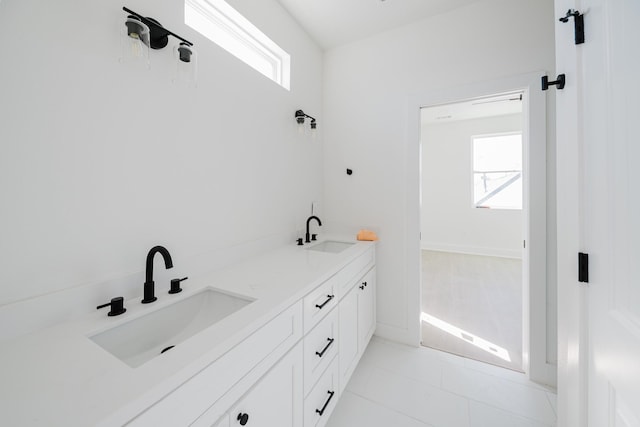 bathroom featuring tile patterned floors, a sink, and double vanity