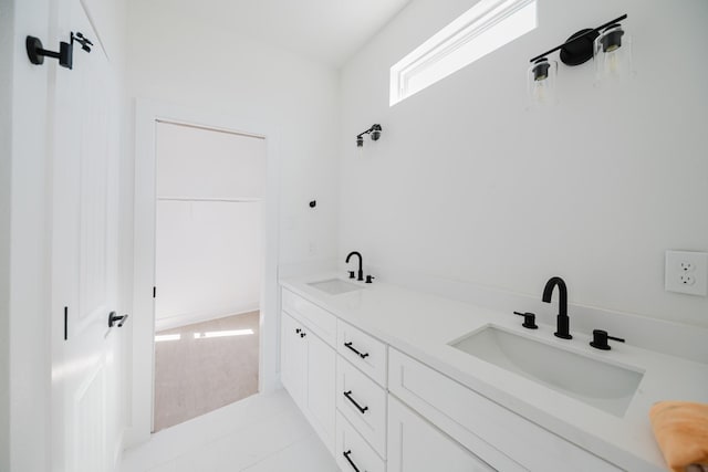 bathroom featuring double vanity, a sink, and tile patterned floors