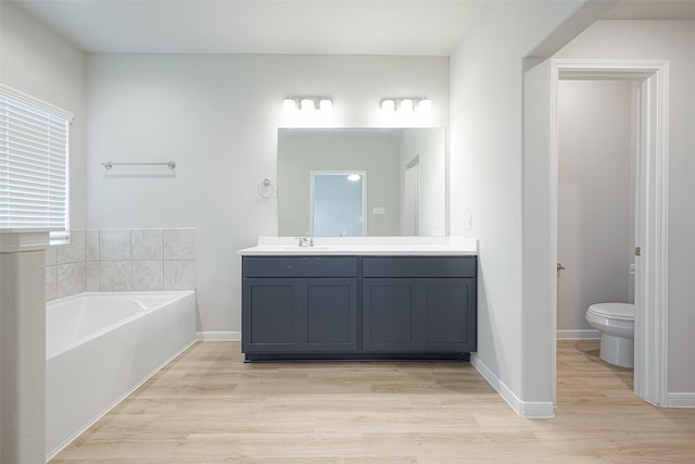 bathroom featuring hardwood / wood-style flooring, vanity, a bathtub, and toilet