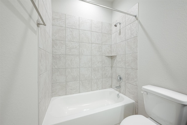 bathroom with toilet and tiled shower / bath combo