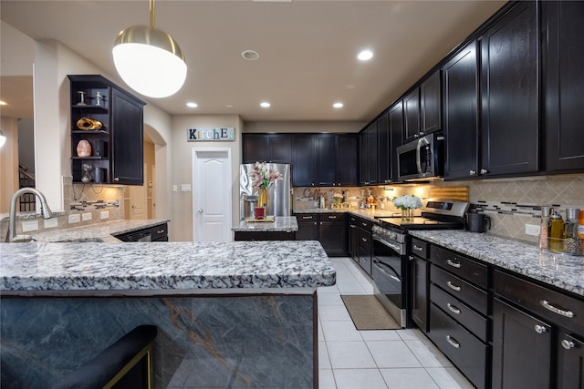 kitchen with appliances with stainless steel finishes, light stone countertops, sink, and hanging light fixtures