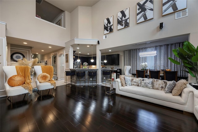 living room with dark hardwood / wood-style flooring and a high ceiling