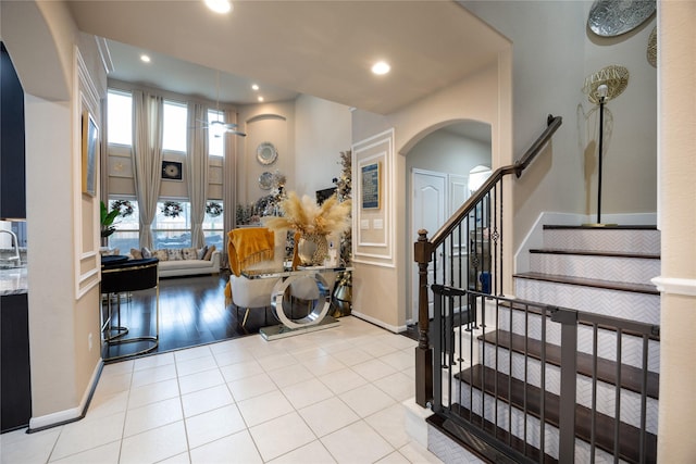 foyer entrance with light tile patterned floors, sink, and ceiling fan