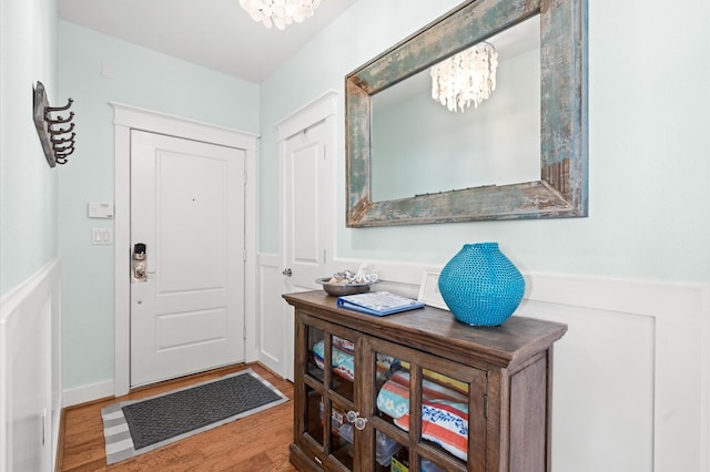 4241 Pointe W Dr Unit 301, Galveston, TX 77554 - foyer with a chandelier, wood finished floors, and a wainscoted wall