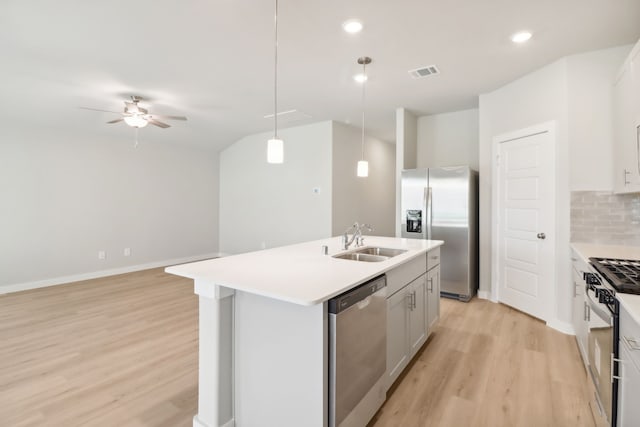 kitchen with decorative light fixtures, sink, backsplash, a kitchen island with sink, and stainless steel appliances