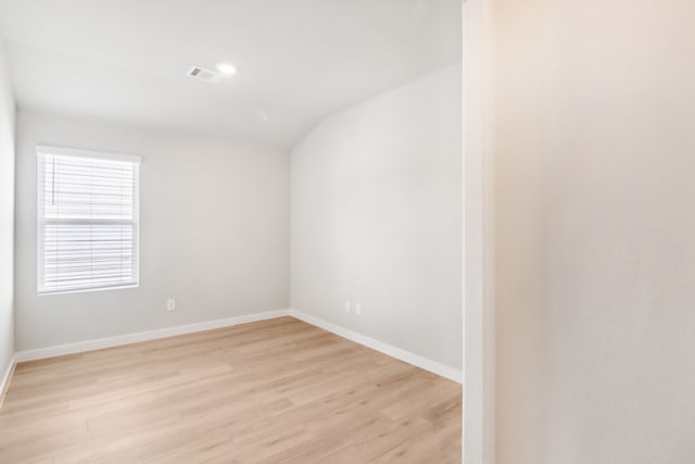 empty room with lofted ceiling and light wood-type flooring