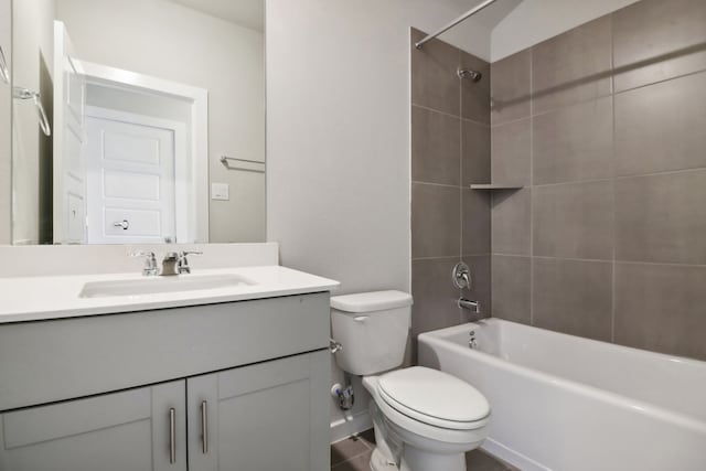 full bathroom with vanity, tiled shower / bath, and toilet