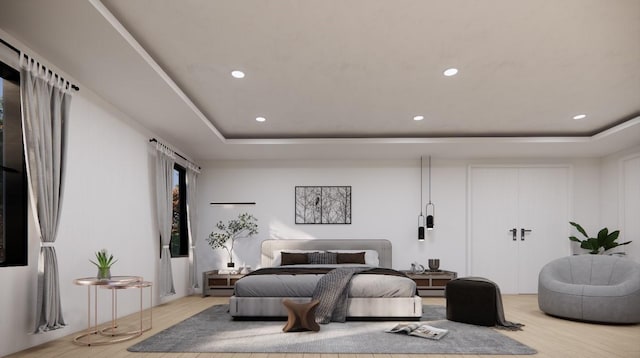 bedroom with a tray ceiling and light hardwood / wood-style flooring