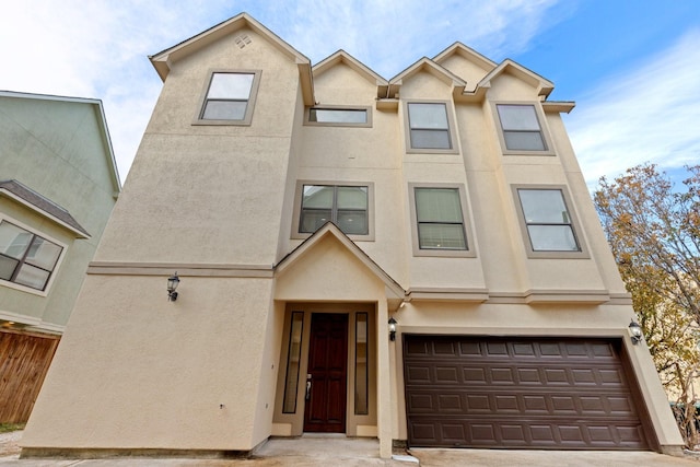 view of property featuring a garage and stucco siding