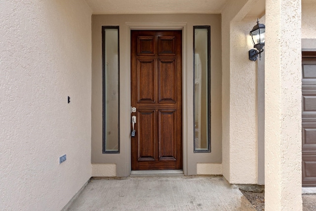 property entrance with stucco siding