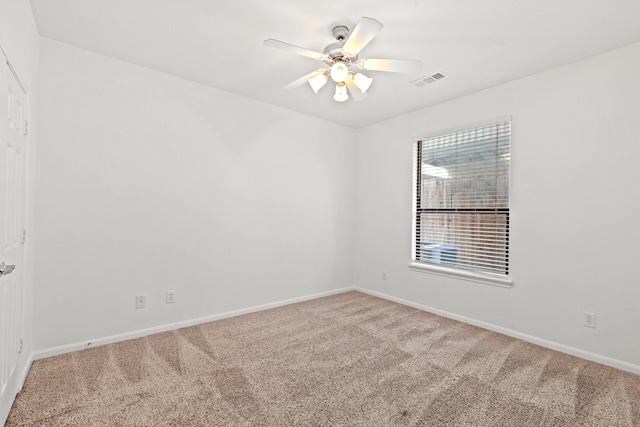 unfurnished room with visible vents, carpet flooring, baseboards, and a ceiling fan